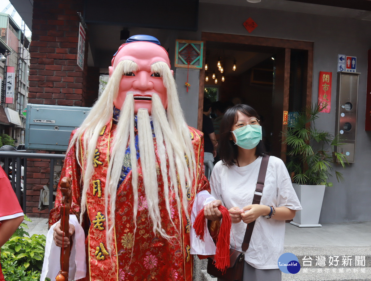 不分男女自月老手中取紅線祈祝好運連連。(記者扶小萍攝)