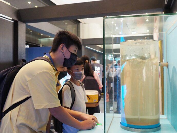 忠明學生現場體驗「水漩渦」關卡,按下按鈕觀察水槽中的水變化。(圖/國立自然科學博物館)