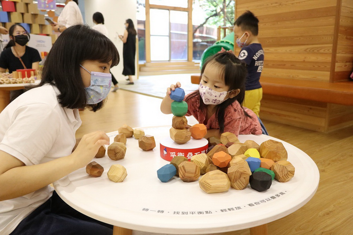 「平衡疊石積木」每一顆木塊都有不同的切面、大小、形狀、重量，孩子可從找到平衡點中，挑戰向上疊高的平衡極限。(信誼基金會提供)