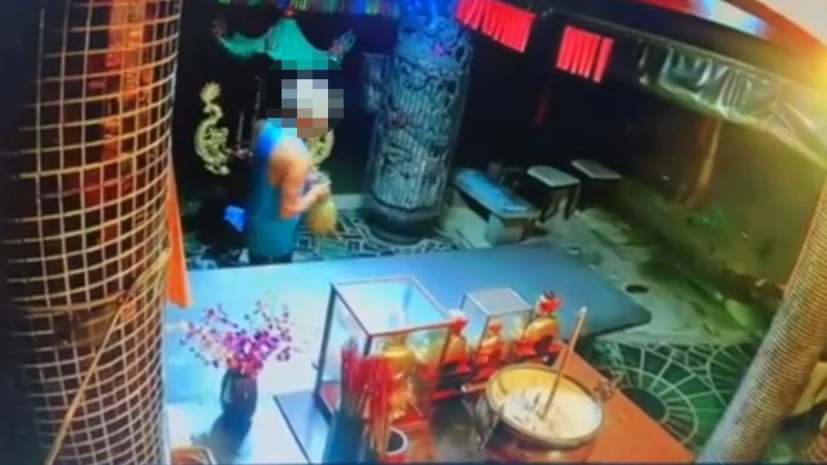 圖:男性犯嫌參拜完後隨手將桌上供品帶走。