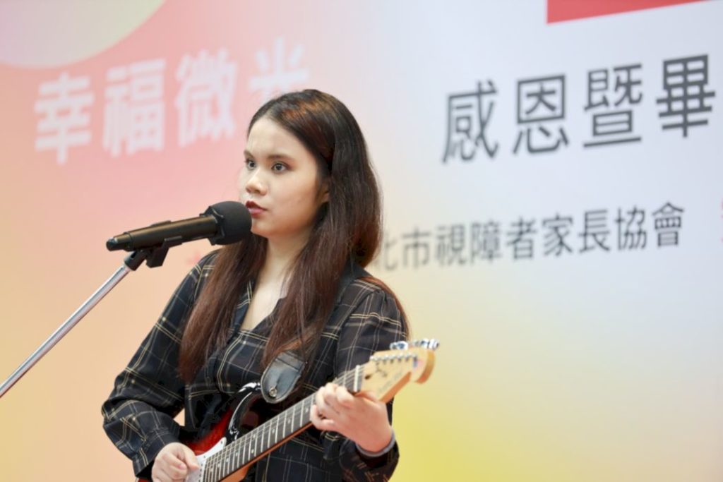 圖6.第六屆畢業生代表瑀婕拿著吉他熟練地自彈自唱《True Colors》