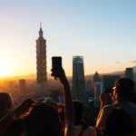 people taking photos of high rise buildings