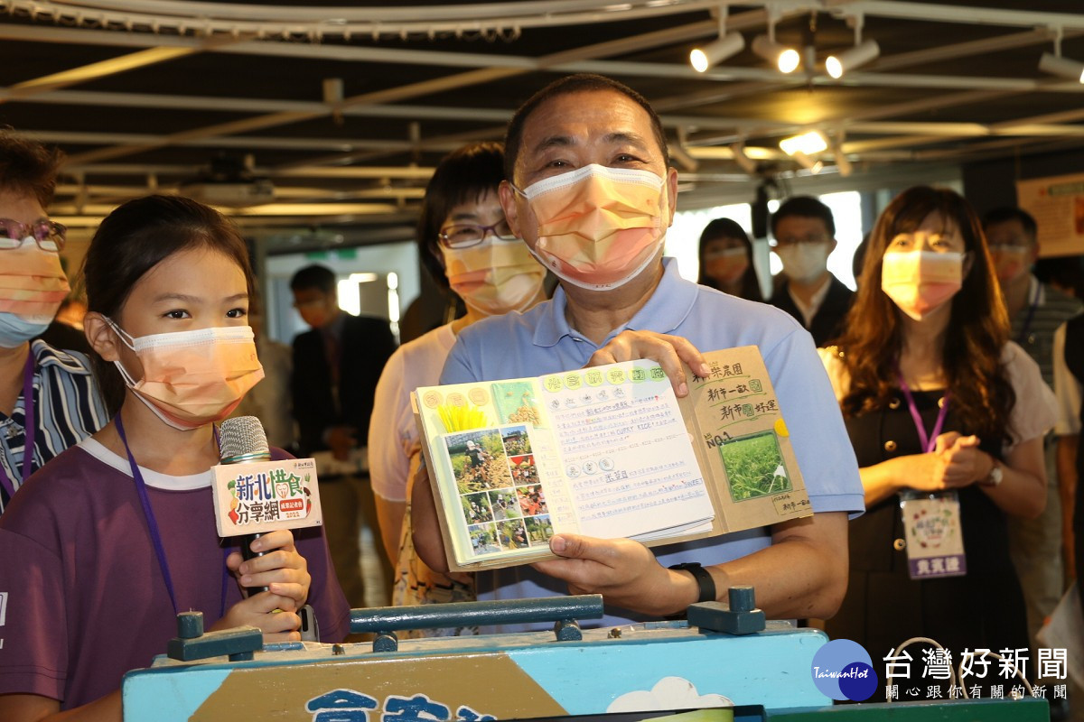 侯友宜展示稻米小書內容 左為淡水區新市國小6年級學生林恩莉