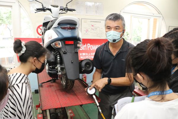 新北高工汽車科老師邱傳福教導女孩如何正確打氣 並量胎壓.jpg