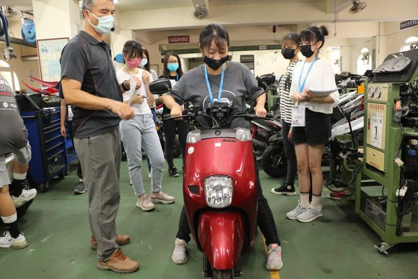 新北高工汽車科老師邱傳福(左)教導女孩如何正確騎乘 並學習如何防禦駕駛.jpg