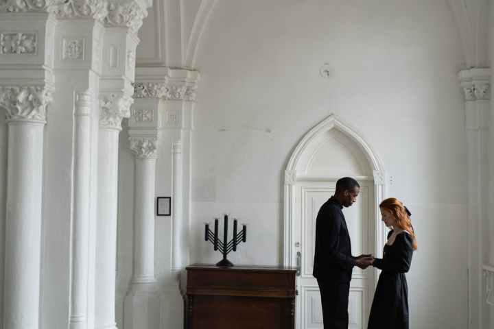 man in black suit standing beside woman in white dress