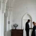 man in black suit standing beside woman in white dress