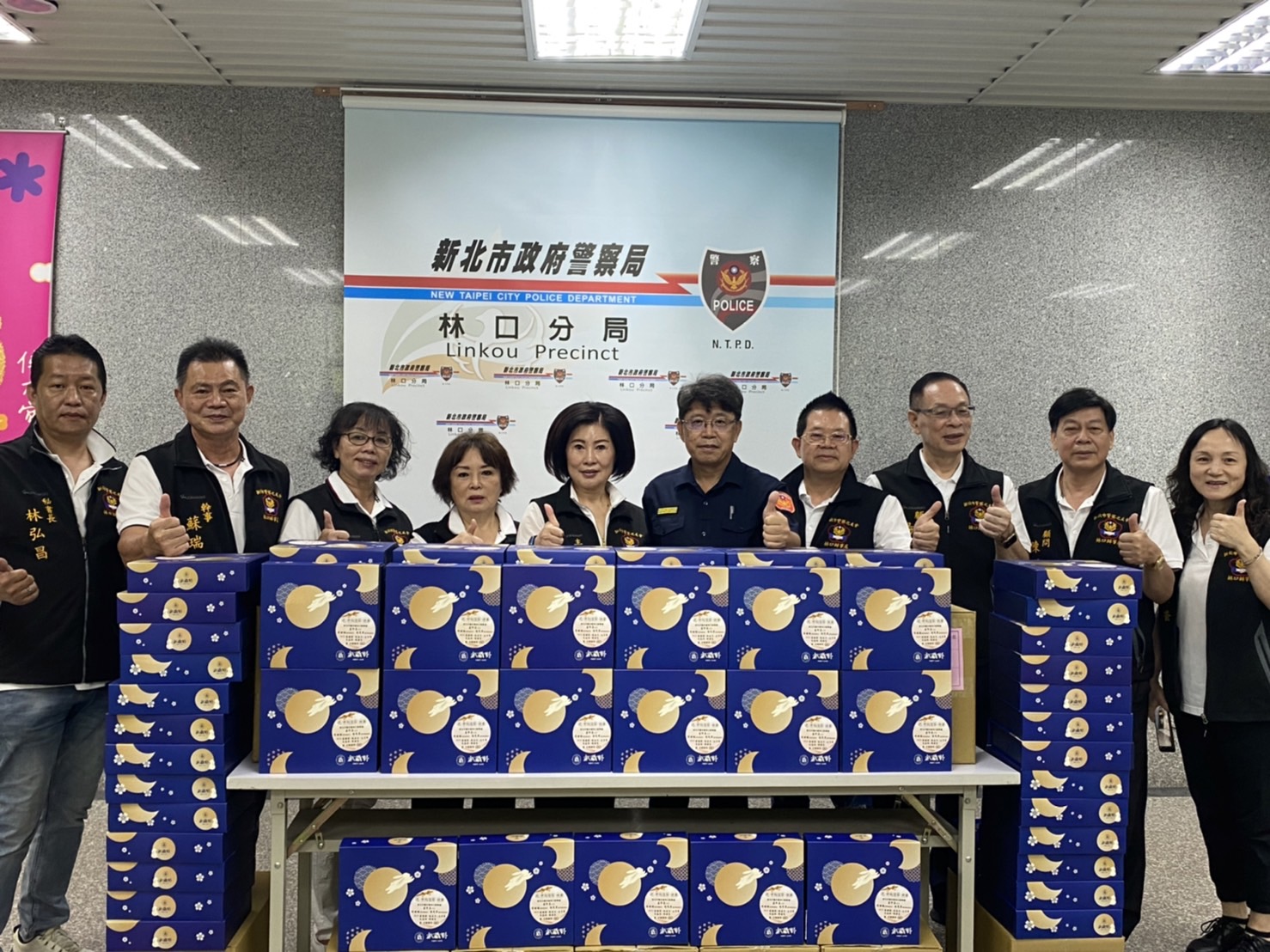 圖片說明:林口分局長陳忠龍(右五)感謝林口警友會辦事處主任盧珍真(左五)貼心準備月餅禮盒贈員警。(記者趙靜姸翻攝)