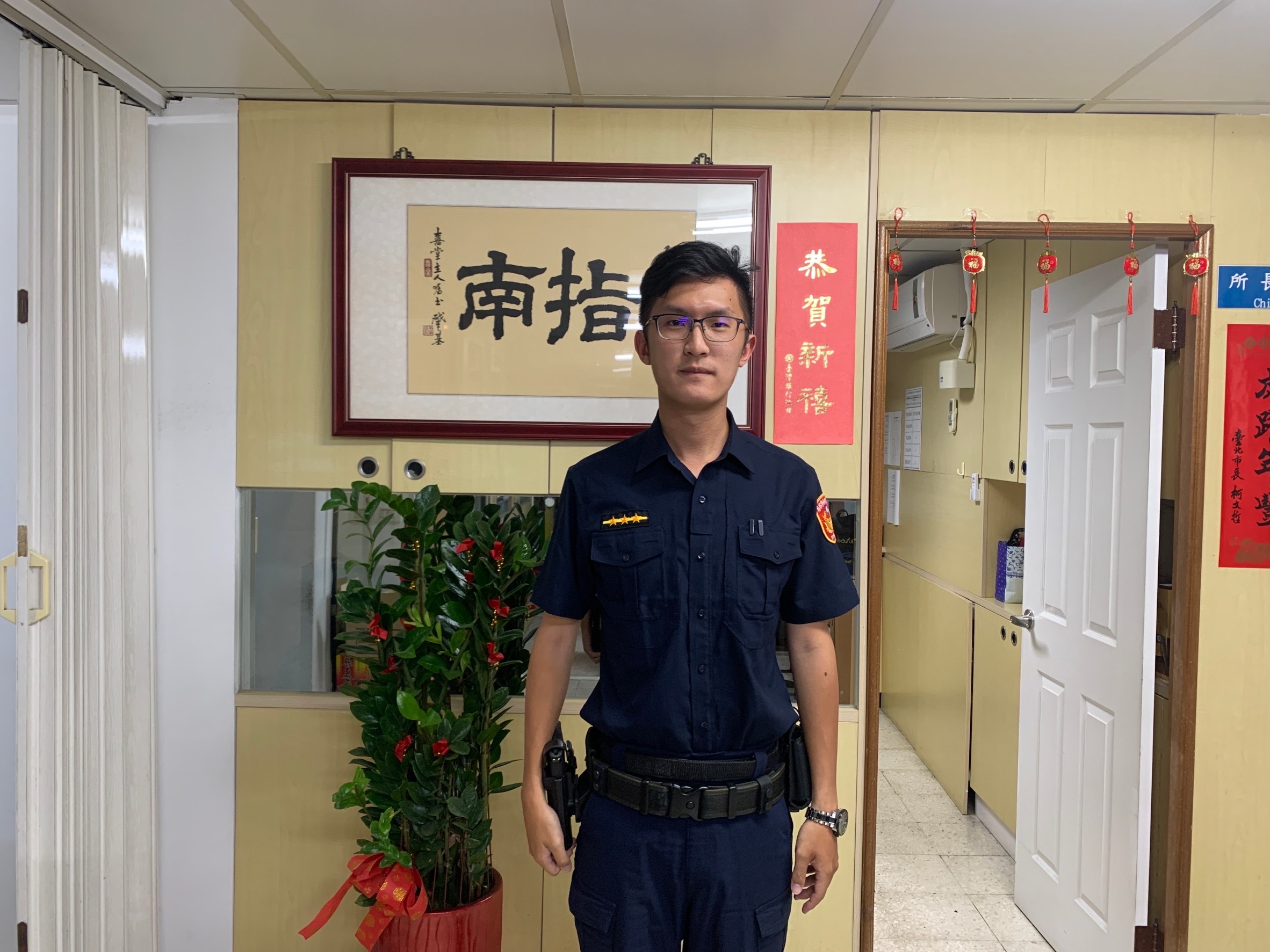 圖片說明:指南所員警林廷威耐心向民眾說明新詐騙手法。(記者趙靜姸翻攝)