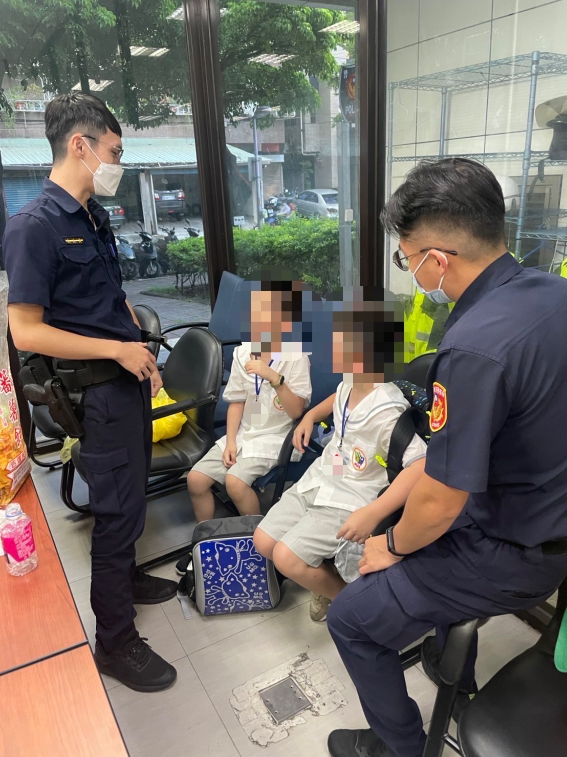 圖片說明:警員張浩軒、吳政峯見兩名男童因害怕情緒不穩、不斷啜泣,便先拿出餅乾安撫男童心情。(記者戴昱弘翻攝)