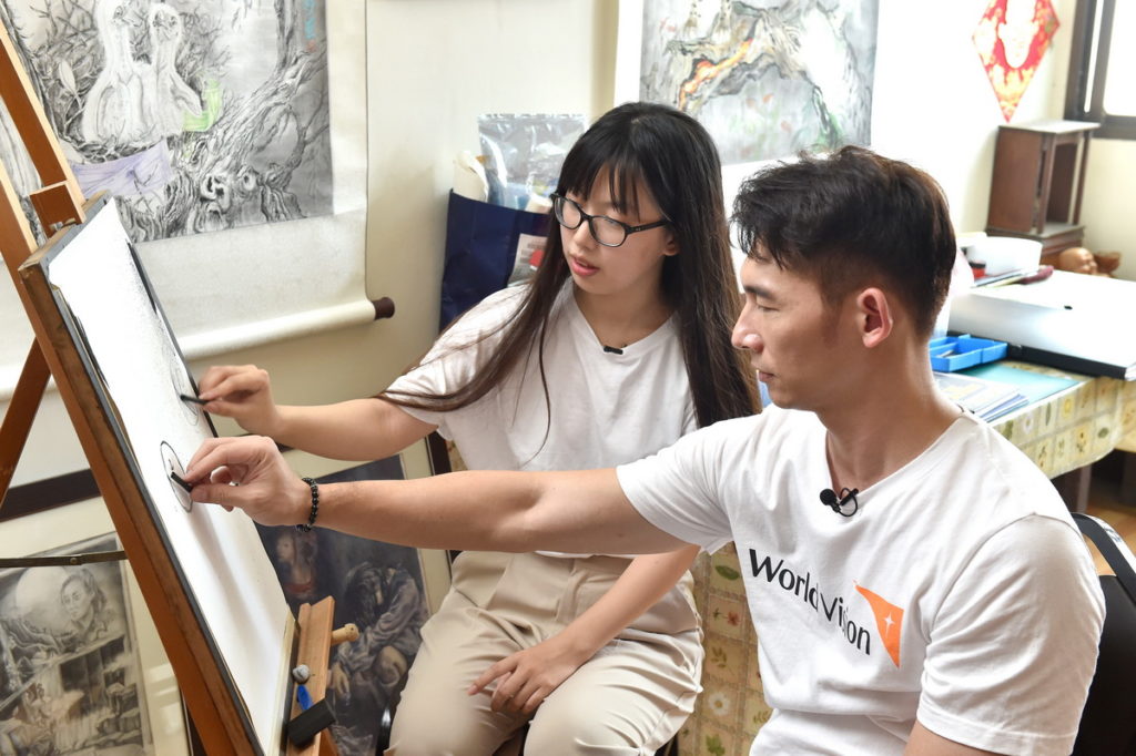 温昇豪聆聽小妤的創作故事，向小妤學用炭筆畫蘋果