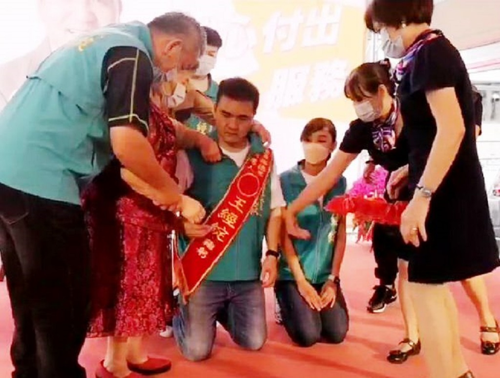 圖片說明:王經綻與牽手彭碩晨雙雙下跪,由母親林秀霞幫兩人披上彩帶,三人眼眶含淚,場面感人。(記者林㤈輝翻攝)