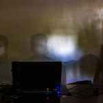 employee sitting near laptop in medical mask during concert
