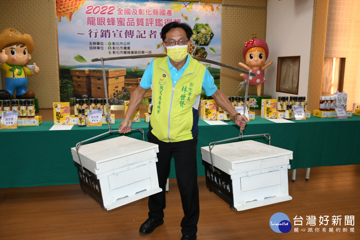 林世賢市長在市農會表揚大會上挑起兩個內各放有八片包括蜂蜜與蜜蜂的「蜂巢片」。圖／記者鄧富珍攝