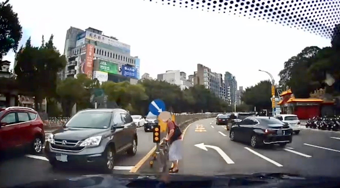 圖片說明:臺北市保大警利用警車警示來往用路人及保護老婦人安全。(記者宋紹誠翻攝)。