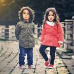 two children standing near concrete fence