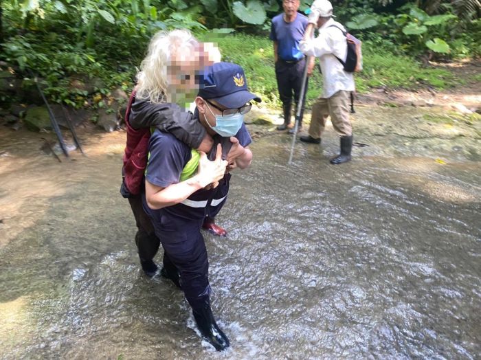 老人跌落小溪受傷 頭份警涉水揹負 積極協助脫困