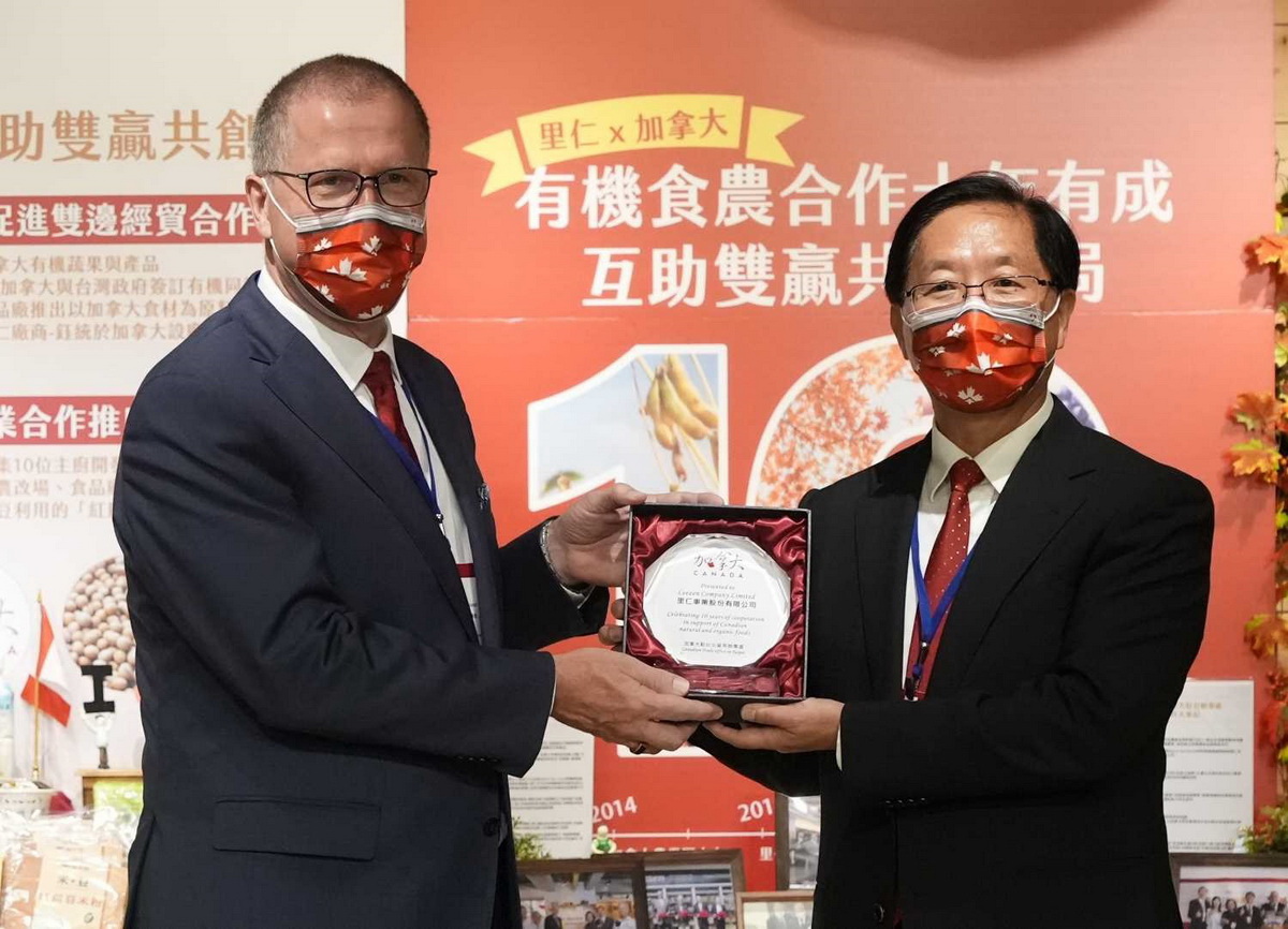加拿大駐臺北貿易辦事處處長 Ed Jager 致贈里仁雙方合作十年紀念獎座，由里仁公司副總韓敬白代表接受