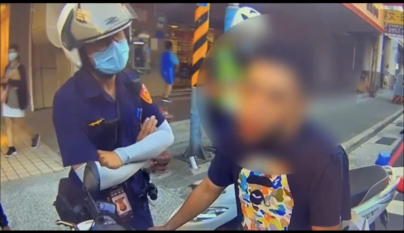 圖片說明:板橋員警攔檢騎車未戴安全帽男子。(記者戴昱弘翻攝)