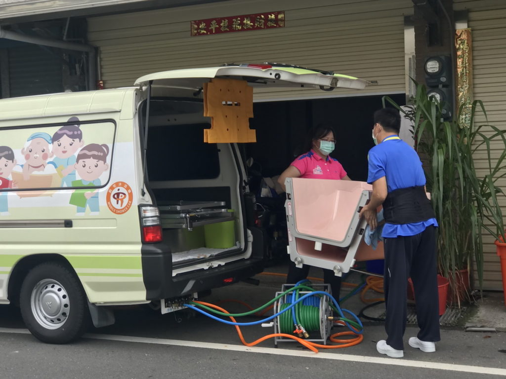 沐浴車工作人員將組合式浴缸搬下車