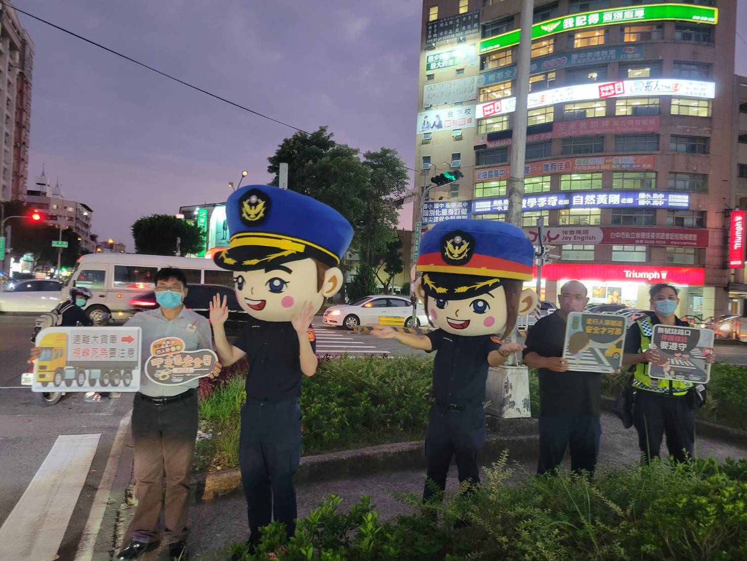 圖片說明:中市警二分局大頭娃娃現身宣導臺中市北區易肇事路口,要你平平又安安!(記者林㤈輝翻攝)