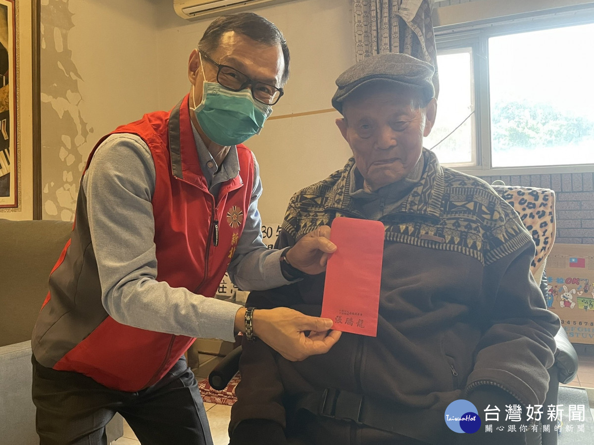 吳伯伯(右)戴上他喜歡的帽子,從臥房出來接受周處長(左)轉贈慈善會的關慰禮金