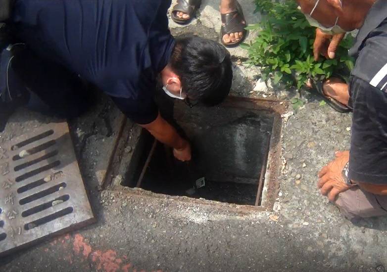 ▲霧峰員警不畏水溝髒污,趴在地上撈起水溝內健保卡 (圖/台中霧峰分局 提供)