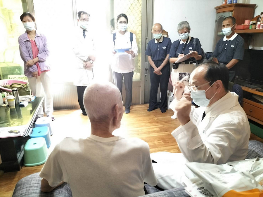 葉家舟主任(右)建議往診鄉親手拿裝滿水寶特瓶增肌。