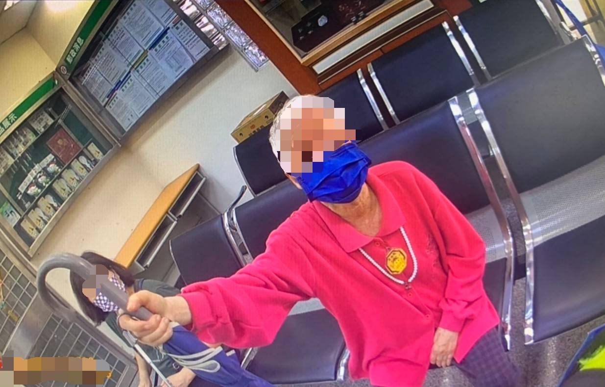 ▲一位白髮蒼蒼老婦拿著雨傘呆坐郵局椅子上，警方獲報趕赴郵局協助 (圖/苗栗縣警察局 提供)