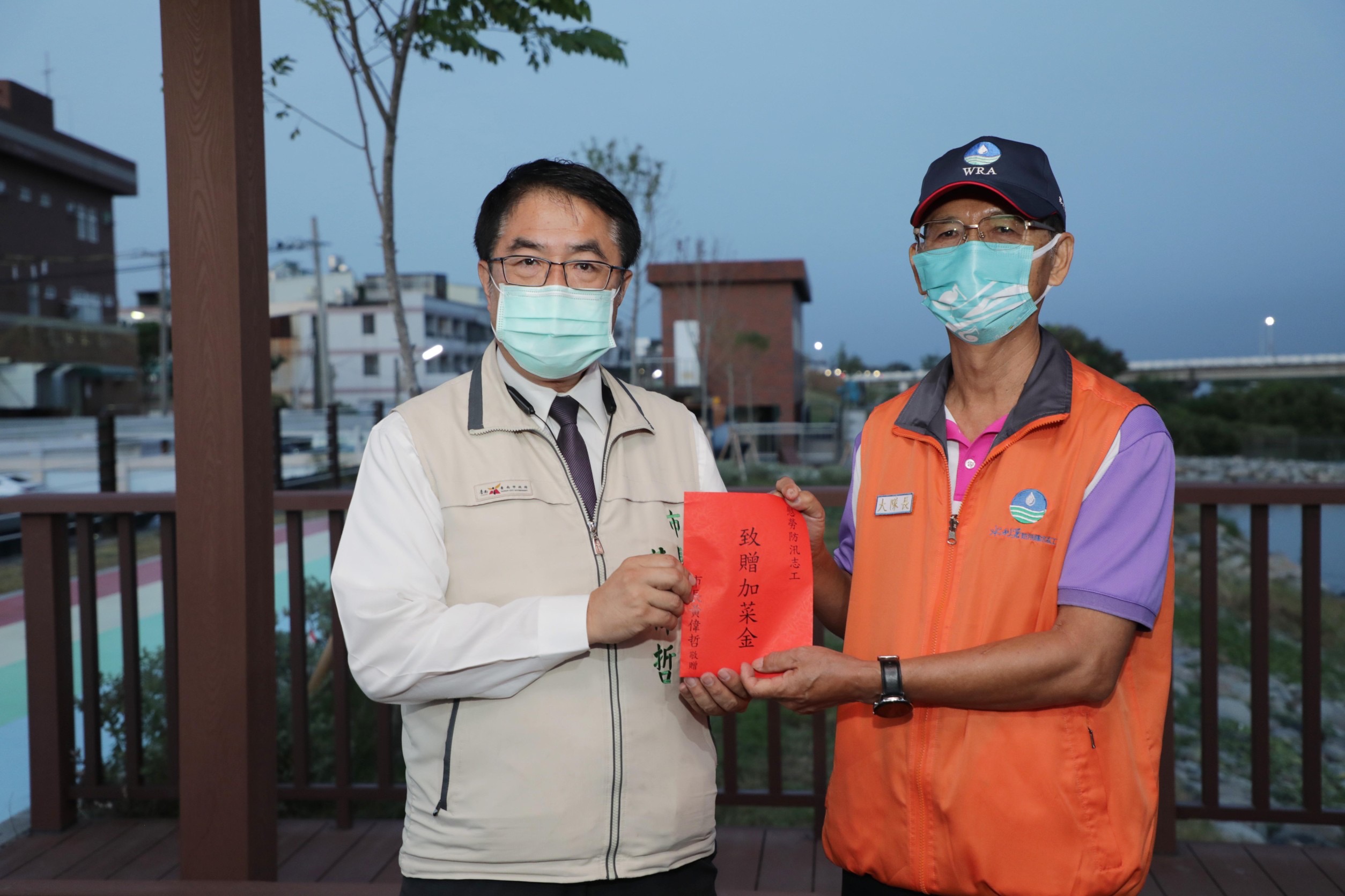 圖片說明:黃偉哲致贈加菜金給防汛護水的志工們,對他們表達敬意與謝意。(記者趙靜姸翻攝)