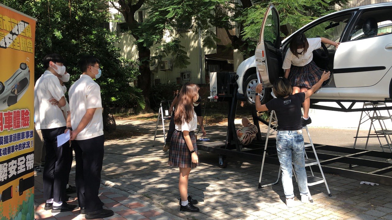 學生兩人一組進入車廂前座繫上安全帶後，實際體驗模擬車輛因意外發生翻覆的感受。 光...