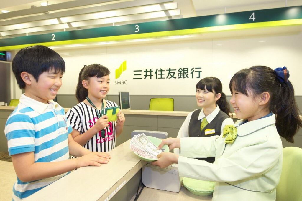 可使用KidZania的專用貨幣「KIZZO」來開設銀行帳戶。銀行在開館後及閉館前30分鐘人潮較多,建議避開這些時段來造訪。(圖片來源:ⒸKCJ GROUP INC.)