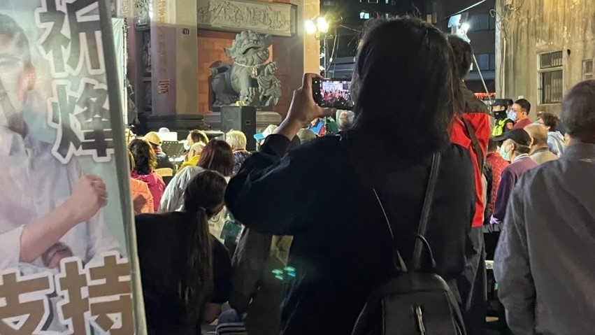 蔡其昌與林祈烽舉辦市政座談會，被支持者發現後方有個女子不斷錄影拍照，經查是市府區公所秘書室主任。市議員林祈烽提供