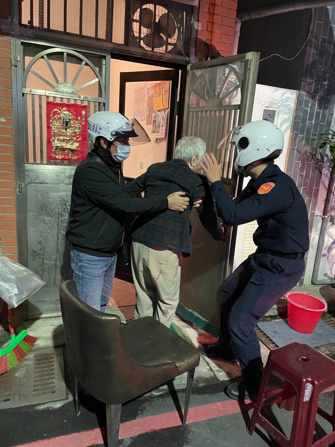 圖:老婦體力不支跌倒家門前,警方與里長現場協助。