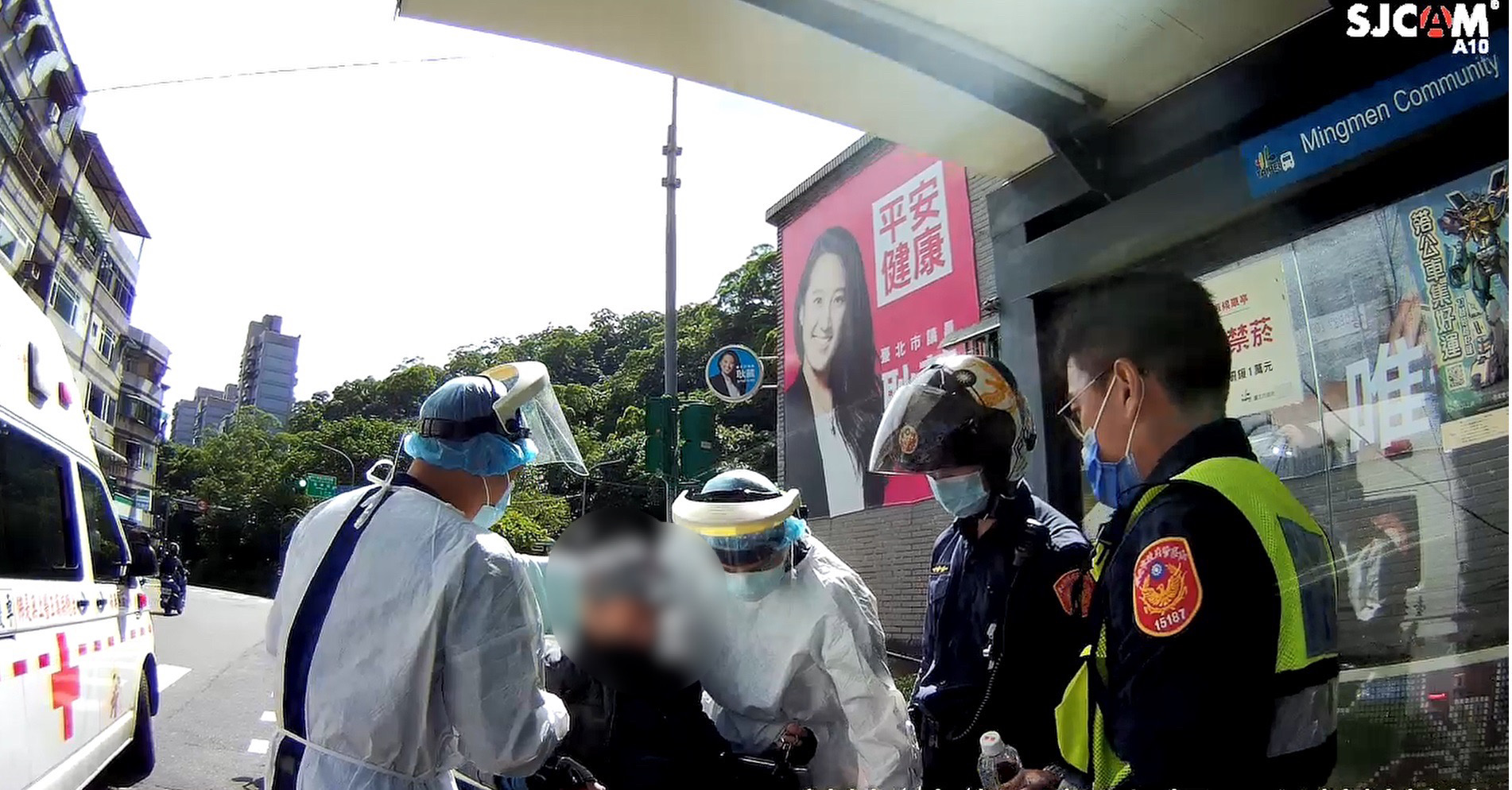 圖片說明:萬芳所警員黃建源、陳致瑋於馬路口救助血糖過低鄔姓駕駛。(記者吳萍翻攝)