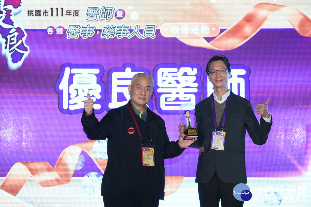 吳致良醫師(右)榮獲桃園市111年度優良醫師獎，由高安邦副市長頒發獎座