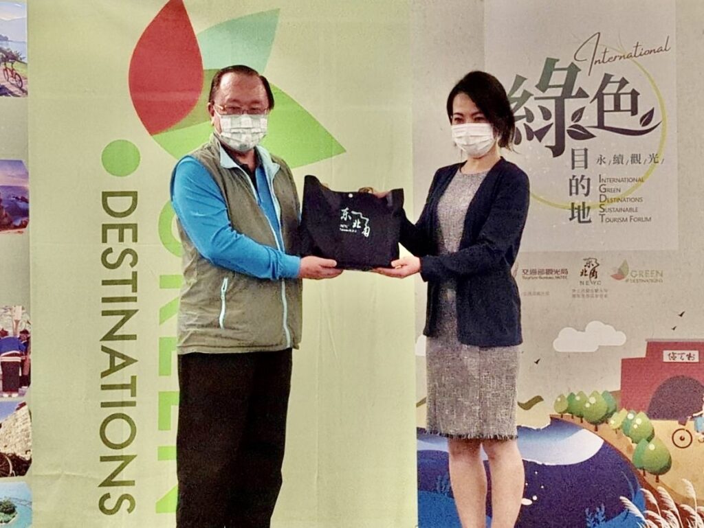 東北角暨宜蘭海岸國家風景區管理處處長馬惠達（左）與日本二世谷町役場商工觀光課代表鈴木惠里互致贈禮物。
