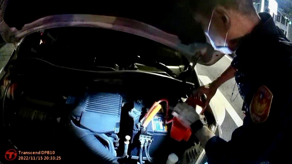 臺北市保安警察大隊員警借助「行動電霸」欲幫忙發動車輛。