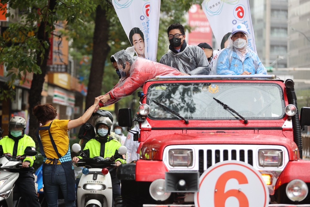喊話台北市民不畏風雨去投票 蔣萬安:這是捍衛價值的聖戰 24 國民黨台北市長候選人蔣萬安24日上午車隊掃街行程前往大安文山區,有熱情民眾跑出與蔣握手互動。