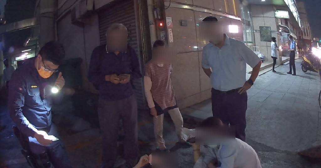 ▲年邁何姓老翁躺臥人行道,熱心民眾在旁照顧並報警協助 (圖/台中市警察局 提供)