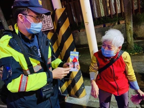 文山第二分局員警特地為年長者戴上反光配件,透過交通宣傳告示牌的解說,讓長者瞭解如何保護自身行的安全。(記者楊國域翻攝)