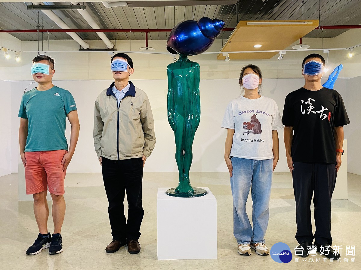 淡古駐村藝術家簡俊成(左1)與參觀民眾以口罩遮臉與作品《寂靜的心》合影,留下有趣的畫面