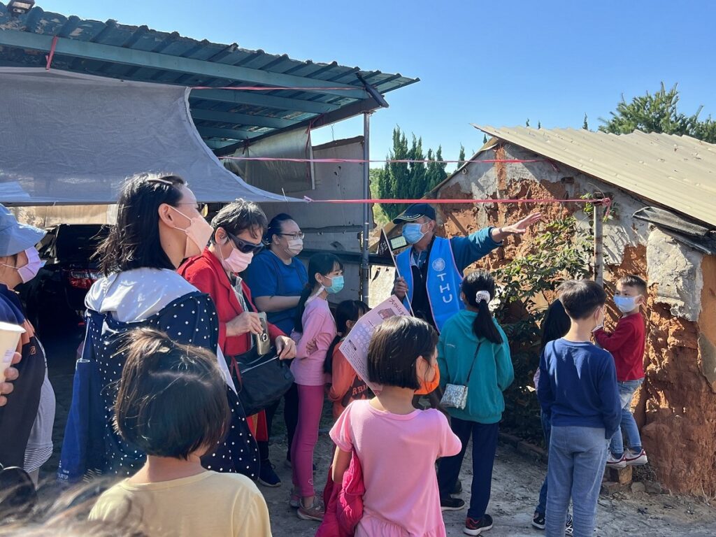 「社區走讀」解說當地紅飛沙的由來,以及說明土角厝的建築方式。(圖/東海大學提供)