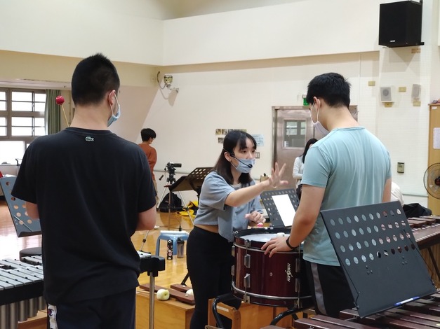 老師指導打擊大鼓的同學演奏的方法.jpg