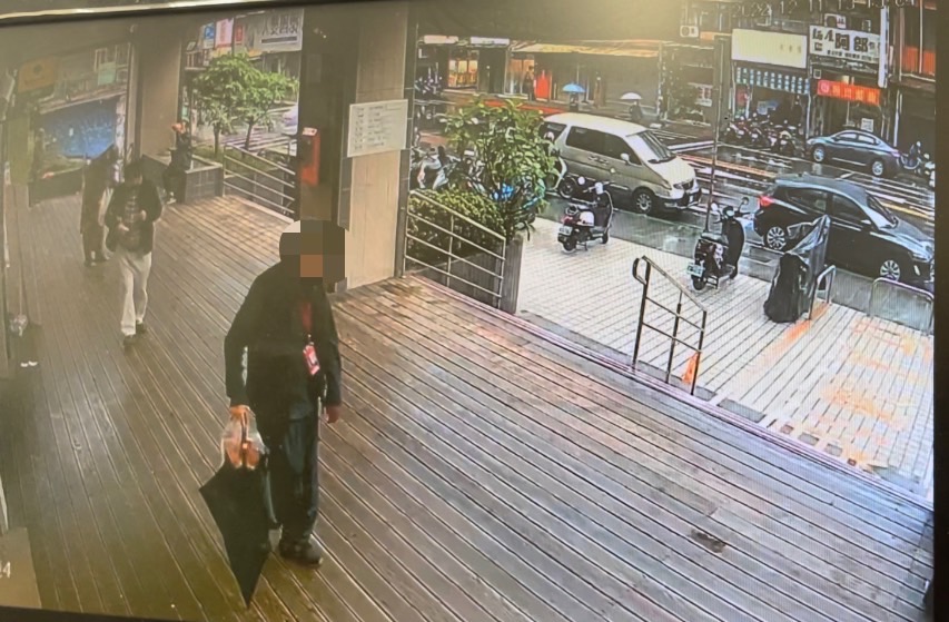 監示器畫面拍到陳姓嫌疑人竊走黑色直傘。(記者楊國域翻攝)