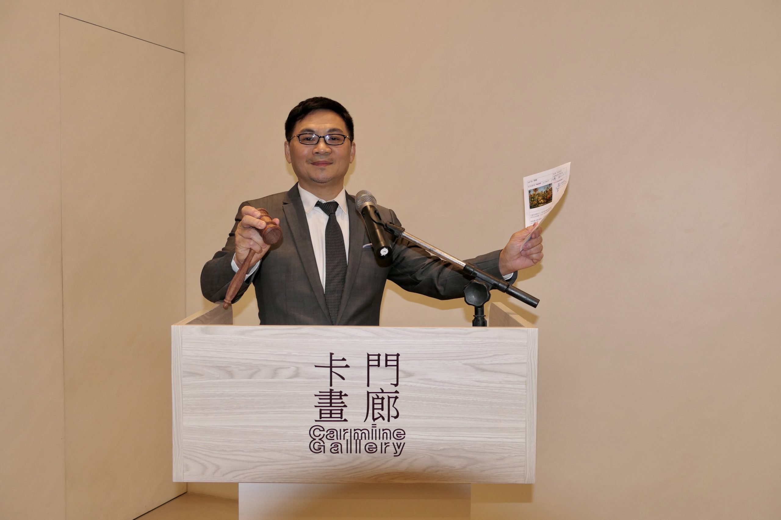 卡門畫廊董事長林辰陽擔任拍賣官,右手所持為特製花梨木拍賣槌。(記者馬治薇攝)