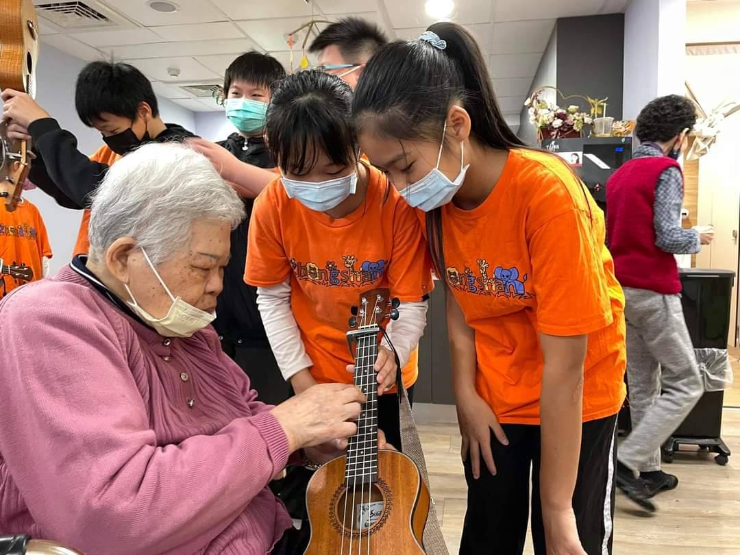 基隆中山國小烏克麗麗團團員當起小老師教導阿公阿嬤們認識與學習烏克麗麗。(圖/基隆中山國小提供)