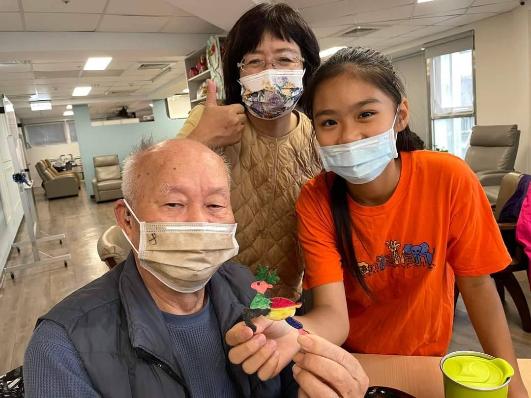 小六生陪大心日照中心長輩一起完成聖誕手作藝術品，校長劉汶琪也嘉許按讚。(圖/基隆中山國小提供)