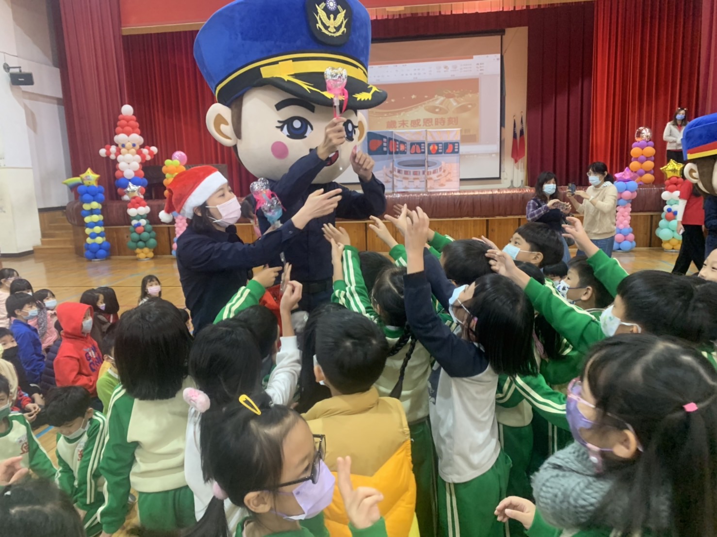 中市警二分局警察大頭娃娃代班當起「聖誕老公公交通宣導大使」，帶給全校師生史無前例驚喜及歡樂。(圖/記者謝榮浤翻攝)