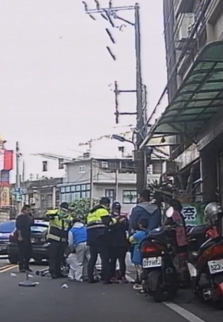 警員鄭旭翔於路倒現場協助救護。